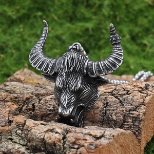 Polished silver stainless steel Odin bull head pendant necklace on natural wood background