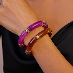 Détail de bracelets en résine marbrée violette et ambre avec perles intercalaires dorées