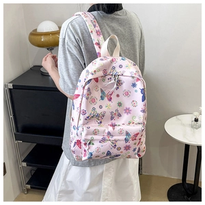 Dettaglio dello zaino rosa con stampe di farfalle colorate e robuste cerniere bianche in nylon