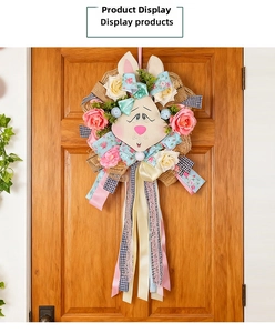 Close-up of Easter rabbit wreath with pink roses and blue ribbons on a wooden door