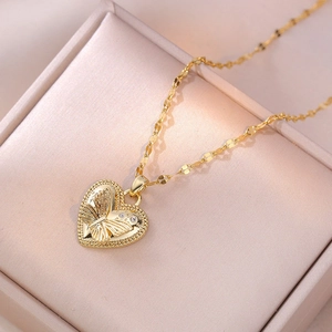 Gouden halsketting met hartvormige hanger, vlinder en stenen op roze doosje