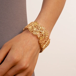 Close-up of gold hollow flower cuff bracelet showing intricate vintage metalwork details
