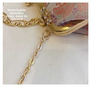 Detail view of the detachable golden chain strap on a floral jacquard shell bag