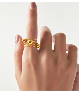 Detail of layered gold-plated titanium steel ring with beads worn on index finger