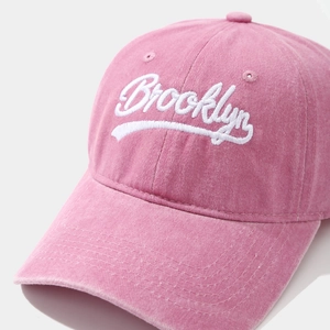 Detailed macro of pink washed cotton baseball cap with white Brooklyn embroidery