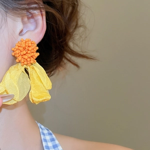 Detail of yellow fabric petals and orange beaded cluster on summer statement earring
