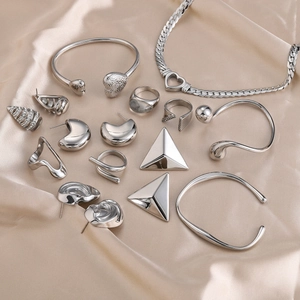 Elegant silver stainless steel jewelry set with heart charms on soft silk background