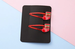 Detail of red sequined Christmas hair clips for kids with colorful stocking ornaments
