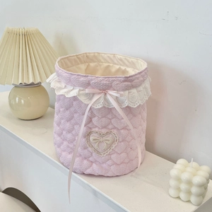 Detail of pink striped quilted fabric storage basket with lace trim and silk bow