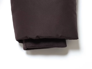 Close-up of the deep brown jacket cuff featuring ribbed knit lining and smooth outer fabric