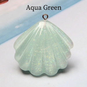Close-up of aqua green resin shell charm with sparkling glitter and silver metal ring