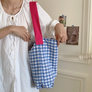 Gros plan sur le sac cabas en toile à carreaux bleus avec bandoulières rose vif