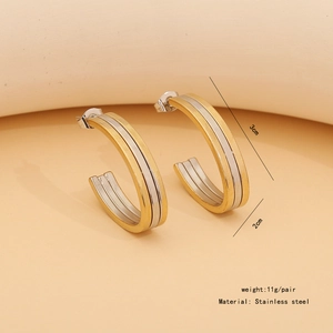 Macro view of C-shaped geometric earrings in gold and silver finish, 3cm diameter