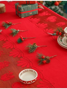 Close-up of red Christmas lace tablecloth with festive shell and gift box patterns