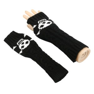 Close-up of black knitted fingerless gloves featuring a white skull pattern print