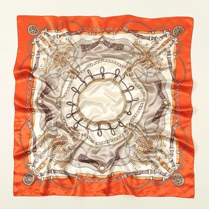 Close-up of elegant square silk scarf with horse chain print and orange border