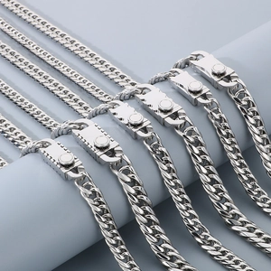 Detail of silver titanium steel Cuban chains featuring polished finish and snap buckles