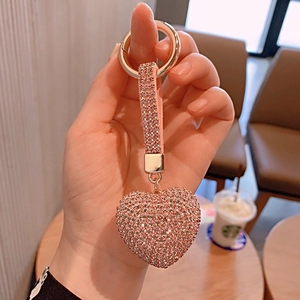 Close-up of a sparkling pink rhinestone heart keychain with gold metal ring detail