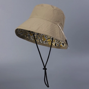 Detail view of water-resistant nylon sun hat with reversible yellow graffiti lining