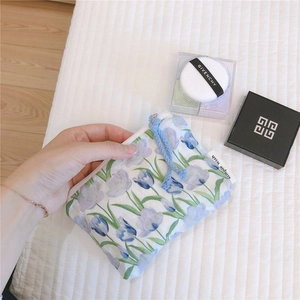 Detail view of cotton pouch featuring blue tulip floral patterns and a small side label
