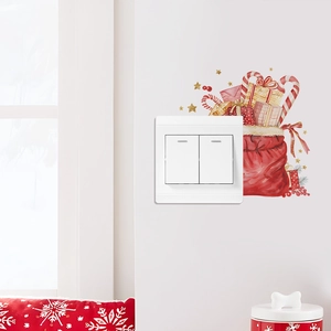 Stickers de Noël avec sacs de cadeaux et sucres d'orge décorant un interrupteur mural