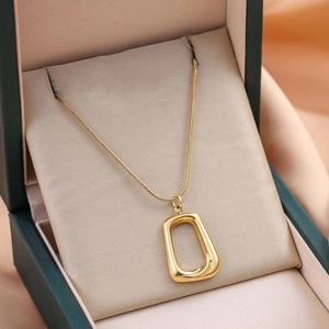 Minimalist gold square pendant necklace on elegant velvet and silk display background