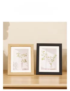 Detail of Nordic minimalist picture frames in natural wood and matte black with white mats