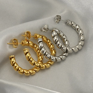 Twisted rope hoop earrings in gold and silver finish on elegant grey silk fabric