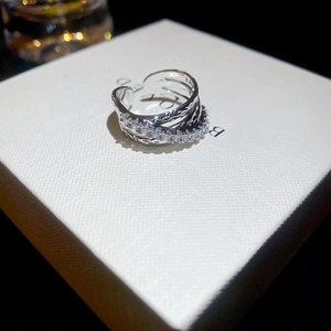 Macro shot of silver triple-layered criss-cross open ring with shimmering zircon stones