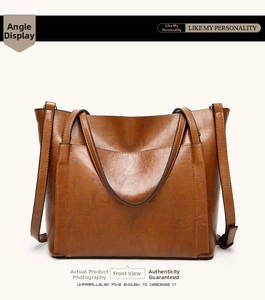 Detail view of brown vintage oil wax leather tote bag with dual handles and long strap