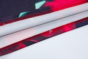 Vue détaillée du tissu imprimé floral avec ourlet à double couture rouge renforcé