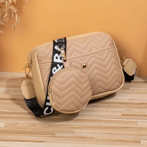 Detalle de bolso bandolera beige acolchado en V con correa CR&B y monedero redondo