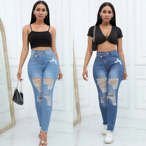 Détails du jean déchiré taille haute avec braguette à boutons et texture denim usé