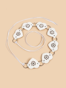 Detail view of white heart-shaped PU leather segments connected with metal rings and star cutouts