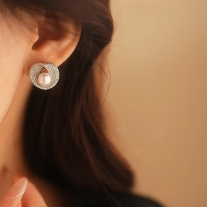 Vue rapprochée d'une boucle d'oreille en perle avec socle en argent et pavé de zircons