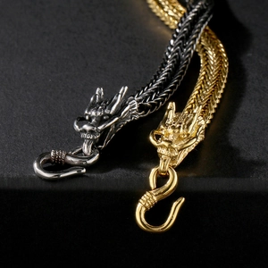 Detailed close-up of gold and silver dragon head bracelet with textured metal link chain