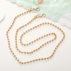 Detailed view of the shiny golden metal bead chain lanyard with secure lobster clasps