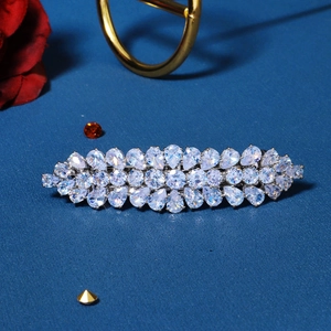 Elegant silver hair clip with pear-cut zircon crystals on a dark textured background