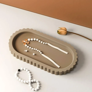 Detailed view of white bead jewelry set with gold flowers on a wavy brown tray