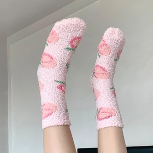Gros plan de chaussettes épaisses en polaire corail rose avec motifs fraises pour femmes
