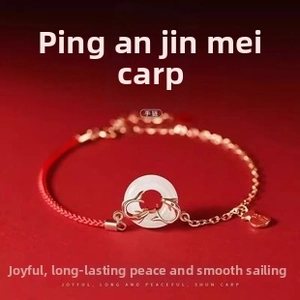 Detail of red woven bracelet with golden koi fish design on a white jade pendant