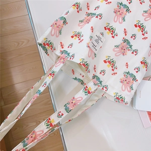 Detailed top view of a white canvas tote bag with pink rabbit and floral patterns