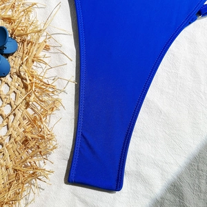 Detailed close-up of sapphire blue textured fabric with premium stitching on swimwear