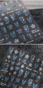 Close-up of M-668 nail stickers with blue butterflies and white flowers on dark background