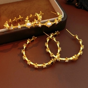 Detail of vintage gold-plated hoop earrings with tiger eye stone and white pearls