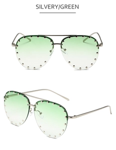Detail of silver aviator sunglasses with green gradient lenses and rivet studs