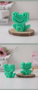 Detailed view of frog-shaped scented candle on a wood slice with minimalist home decor