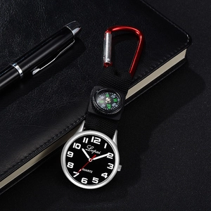Detail of quartz pocket watch with built-in compass and red carabiner on a notebook