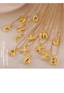 Macro detail of 3D bubble style alphabet pendants in polished gold finish