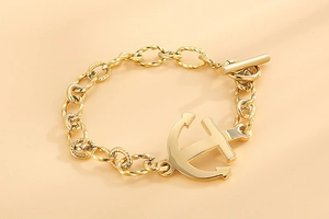 Macro shot of gold anchor bracelet with textured oval links and classic OT toggle clasp